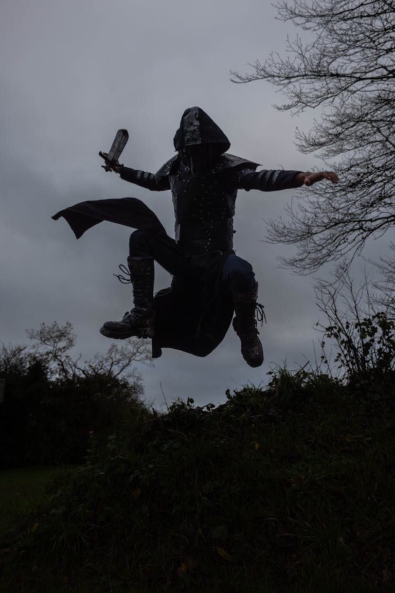 A medieval warrior in armor leaps with a sword, showcasing action and intensity.