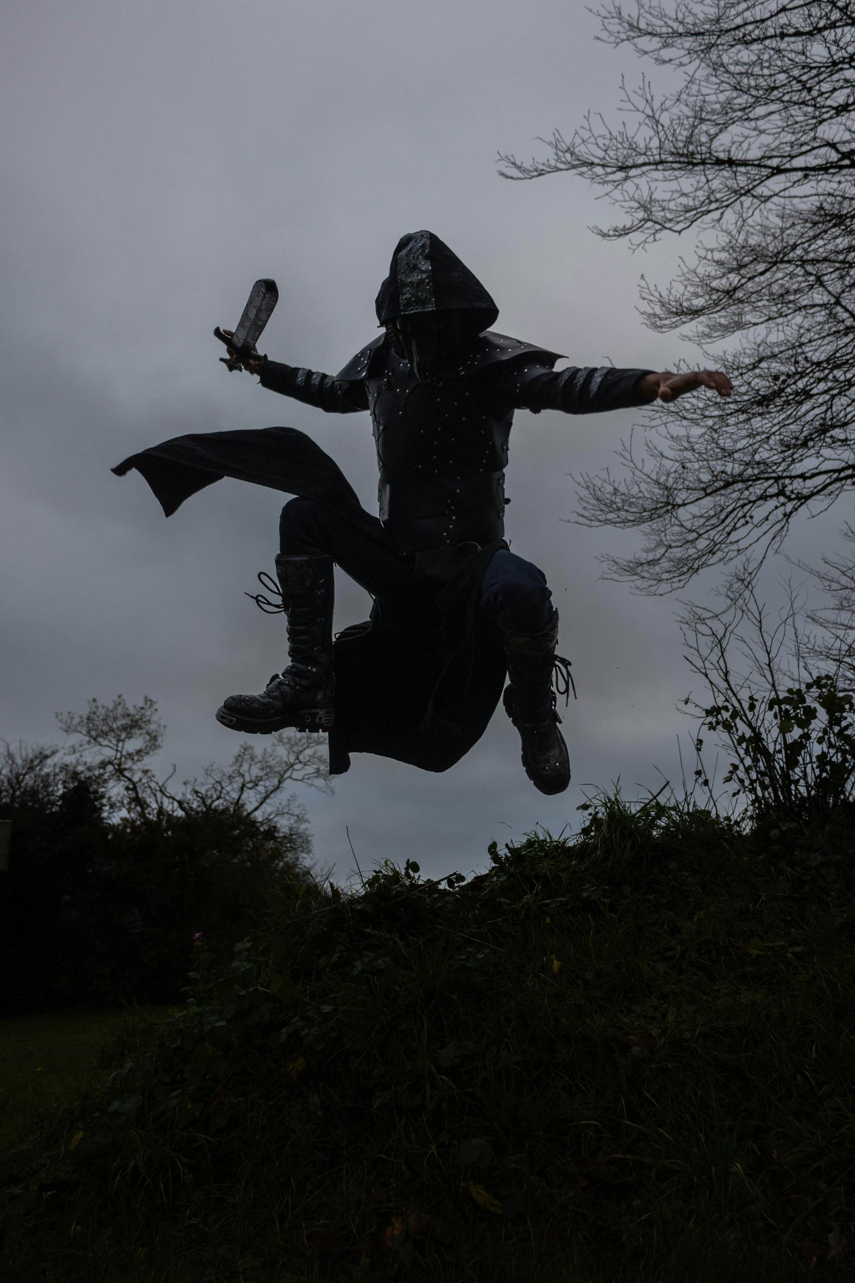 A medieval warrior in armor leaps with a sword, showcasing action and intensity.